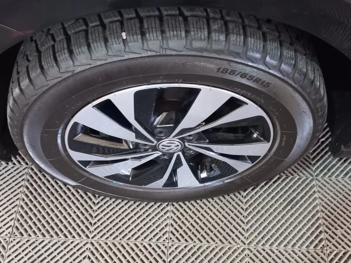 Gros plan sur la roue avant droite d'une Volkswagen Polo noire avec jante alliage bicolore moderne.