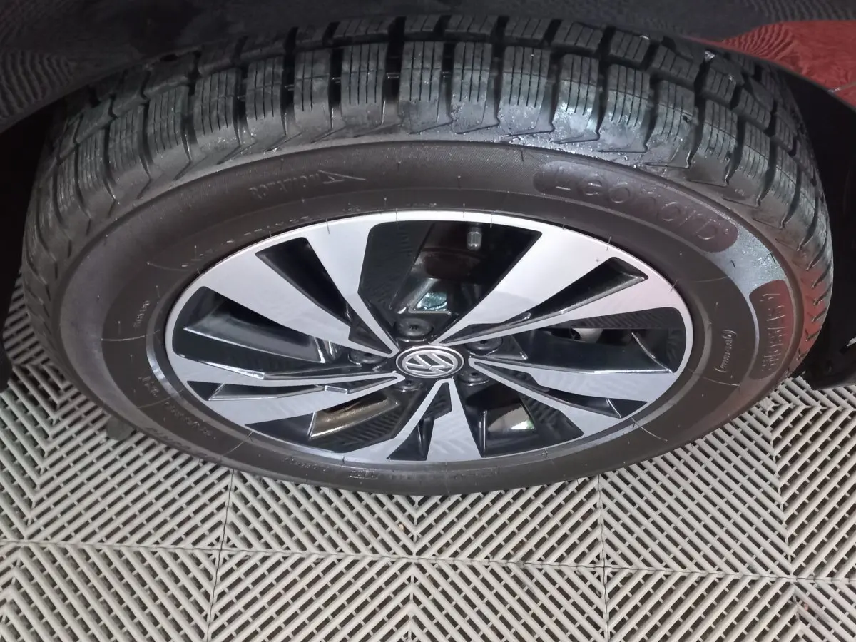 Gros plan sur la roue avant droite noire d'une Volkswagen Polo 1.0 TSI 95 DSG7 Lounge Business avec jante alliage bicolore.