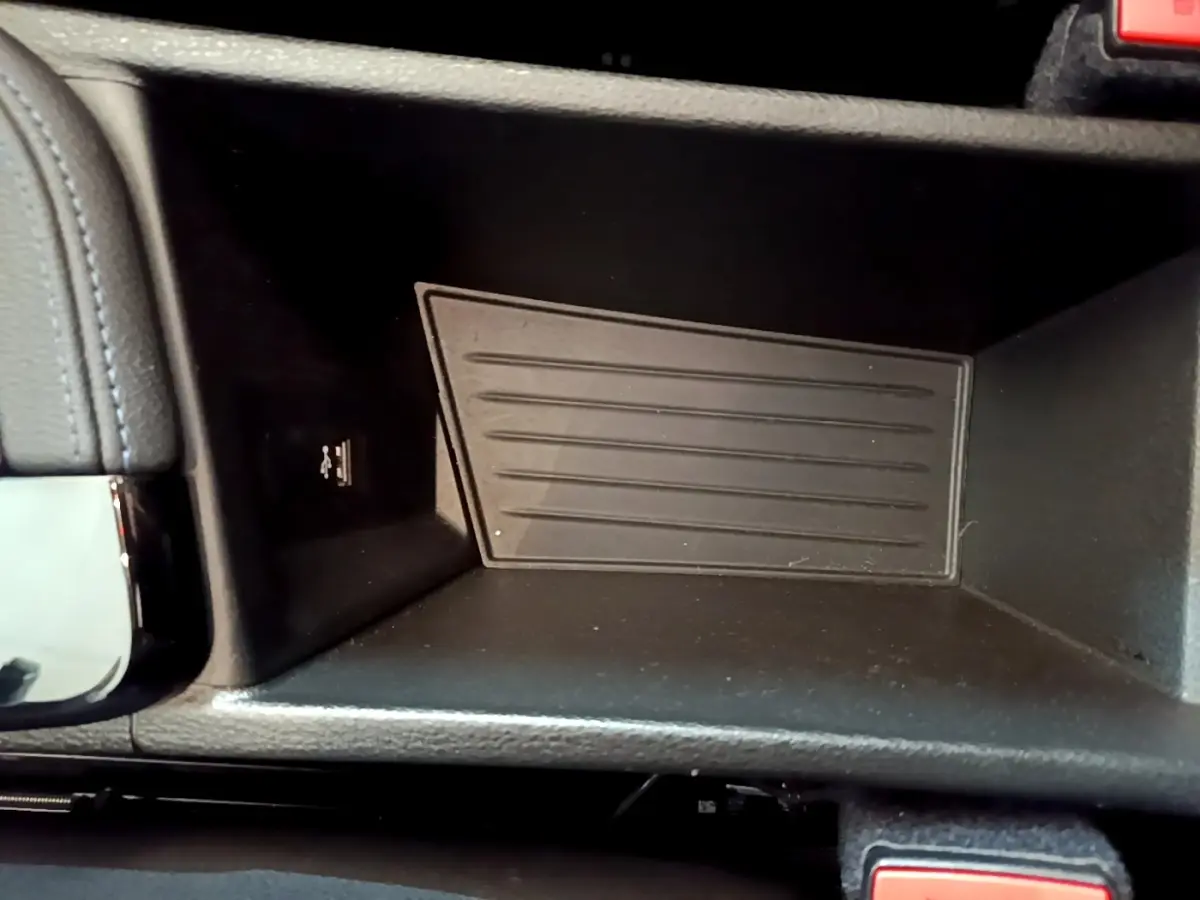 Gros plan sur le compartiment de rangement noir avec port USB, intérieur de la BMW X1 sDrive18i M Sport blanc 2022.