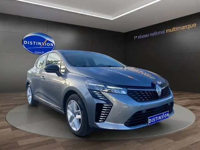 Renault Clio V gris schiste vue 3/4 avant droit, avec calandre noire et feux LED Pure Vision allumés.