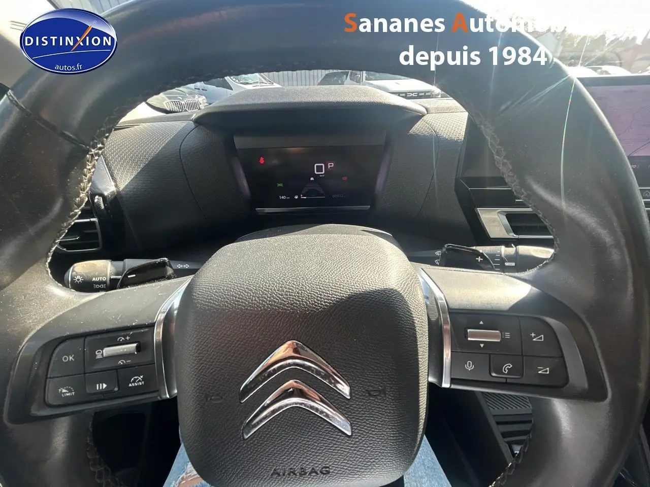 Vue rapprochée du volant cuir noir de la Citroën C4 2021 avec commandes intégrées et tableau de bord digital.