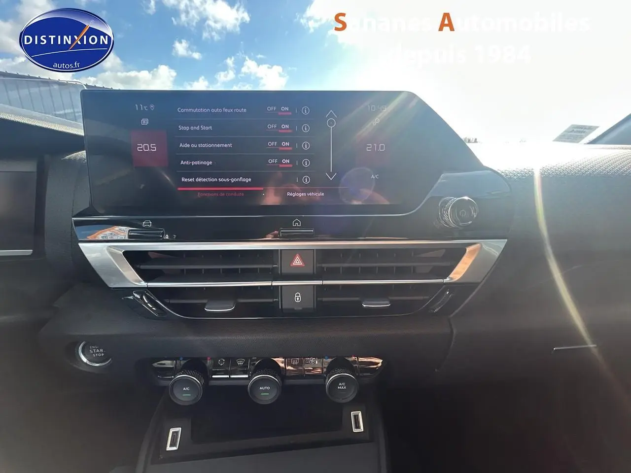 Tableau de bord de Citroën C4 2021 avec écran tactile et commandes de climatisation sous un ciel ensoleillé.