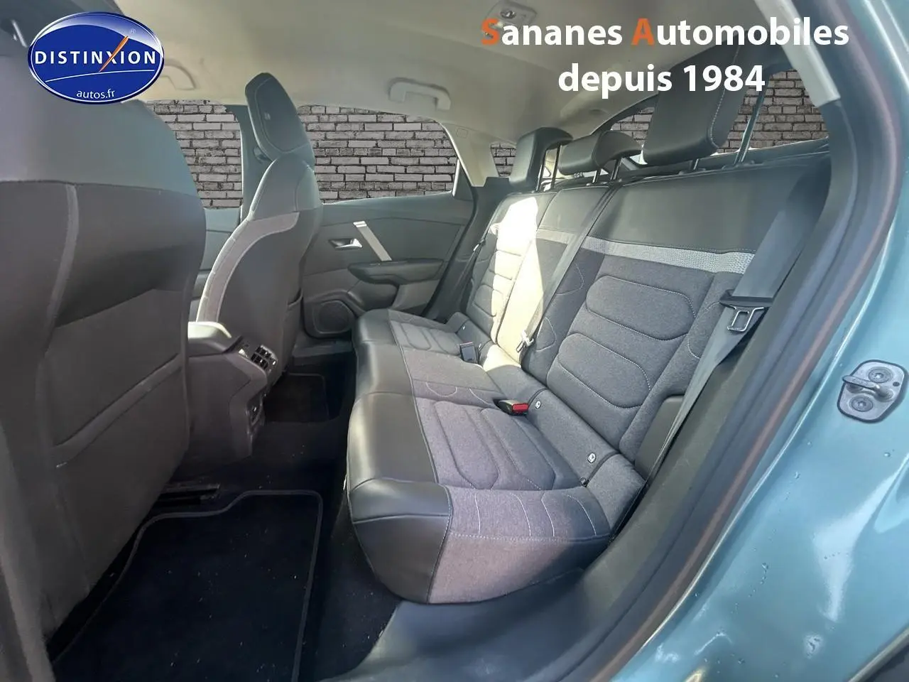 Vue intérieure arrière côté droit d'une Citroën C4 2021 bleu clair avec sièges tissu et cuir noir.