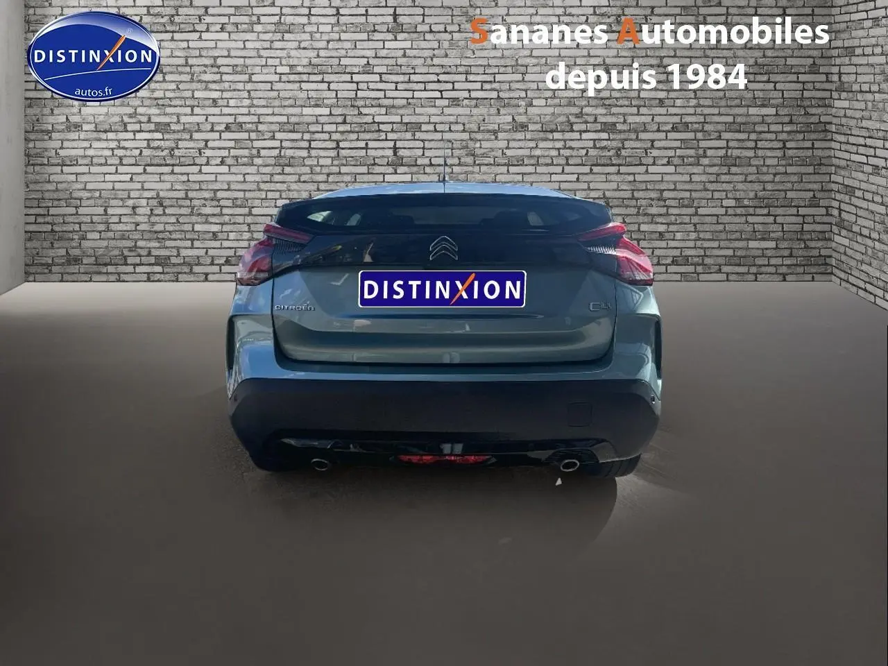 Vue arrière d'une Citroën C4 bleu clair 2021 avec feux distinctifs et double sortie d'échappement dans un garage.