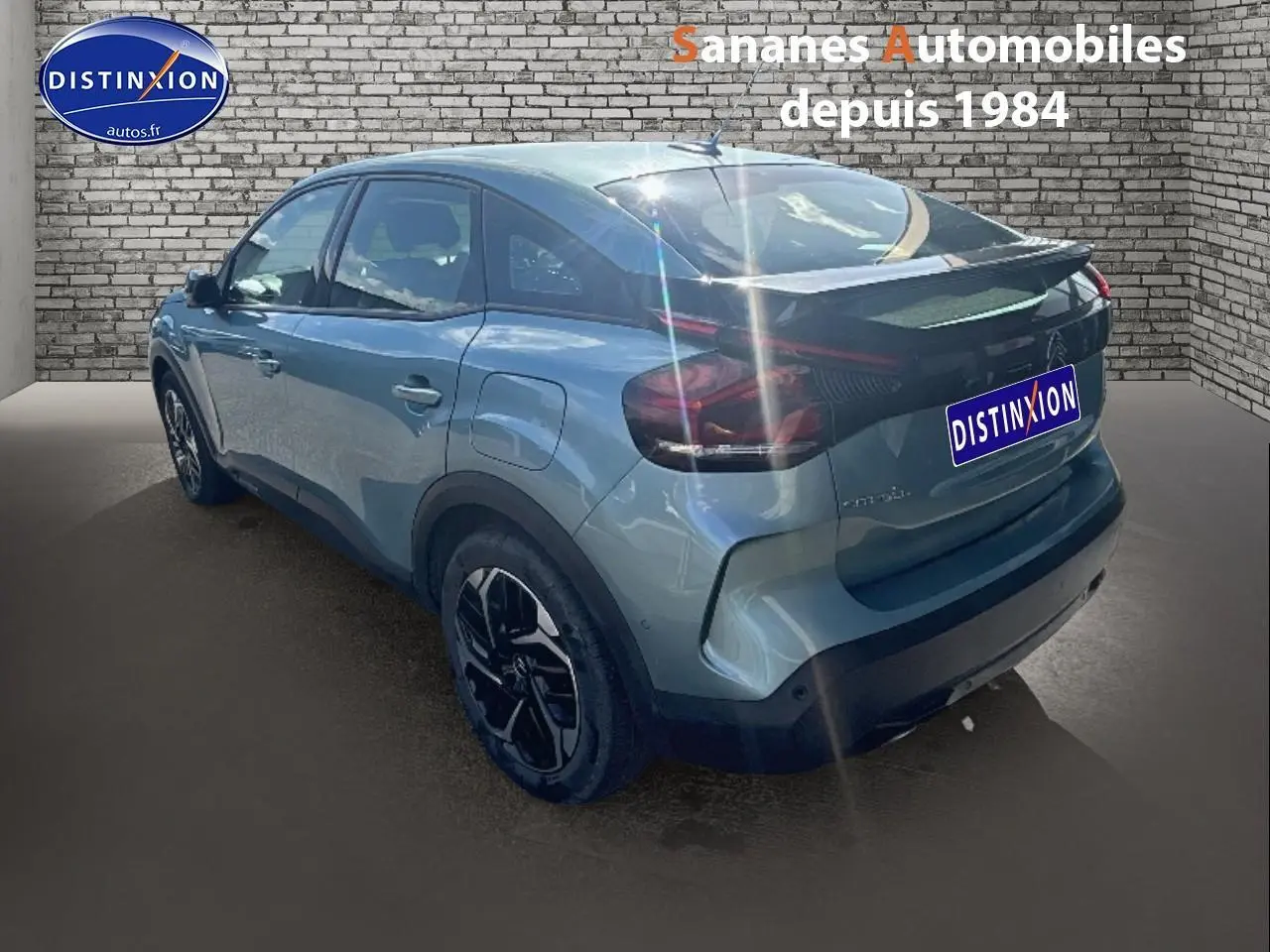 Vue 3/4 arrière droite d'une Citroën C4 bleu clair métallisé avec jantes alliage noires et toit noir.