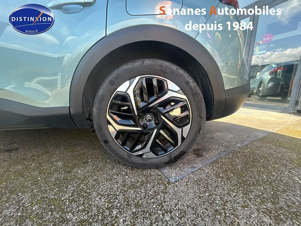 Gros plan sur la roue arrière droite d'une Citroën C4 bleu clair avec jante alliage 18 pouces au design moderne.