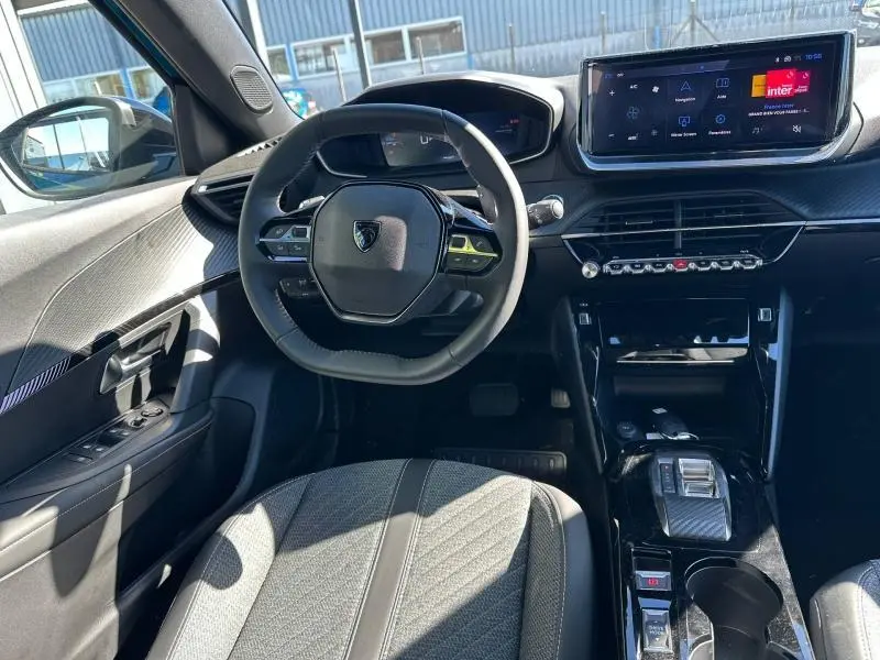 Intérieur Peugeot 2008 2025 vu côté conducteur, volant compact, écran tactile central et finitions noires modernes.