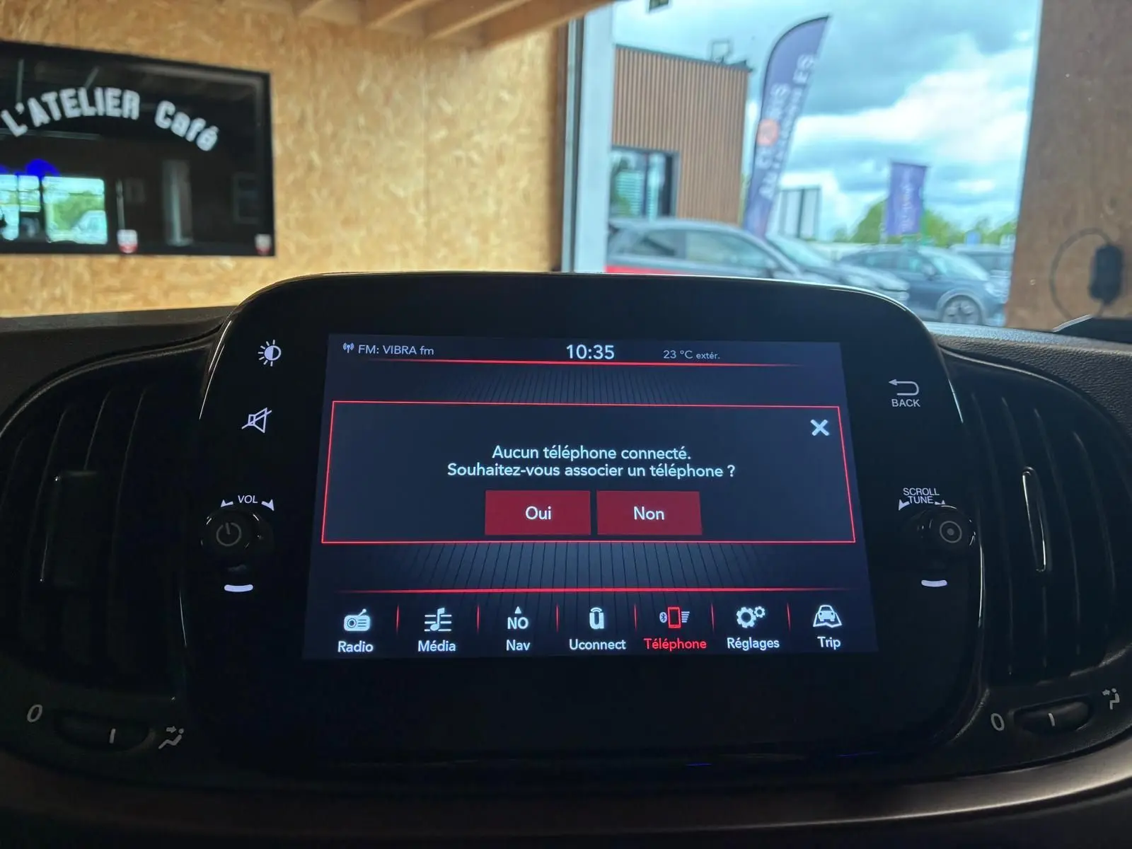 Écran tactile central de la Fiat 500 blanc crème, affichant le menu de connexion téléphone en intérieur.