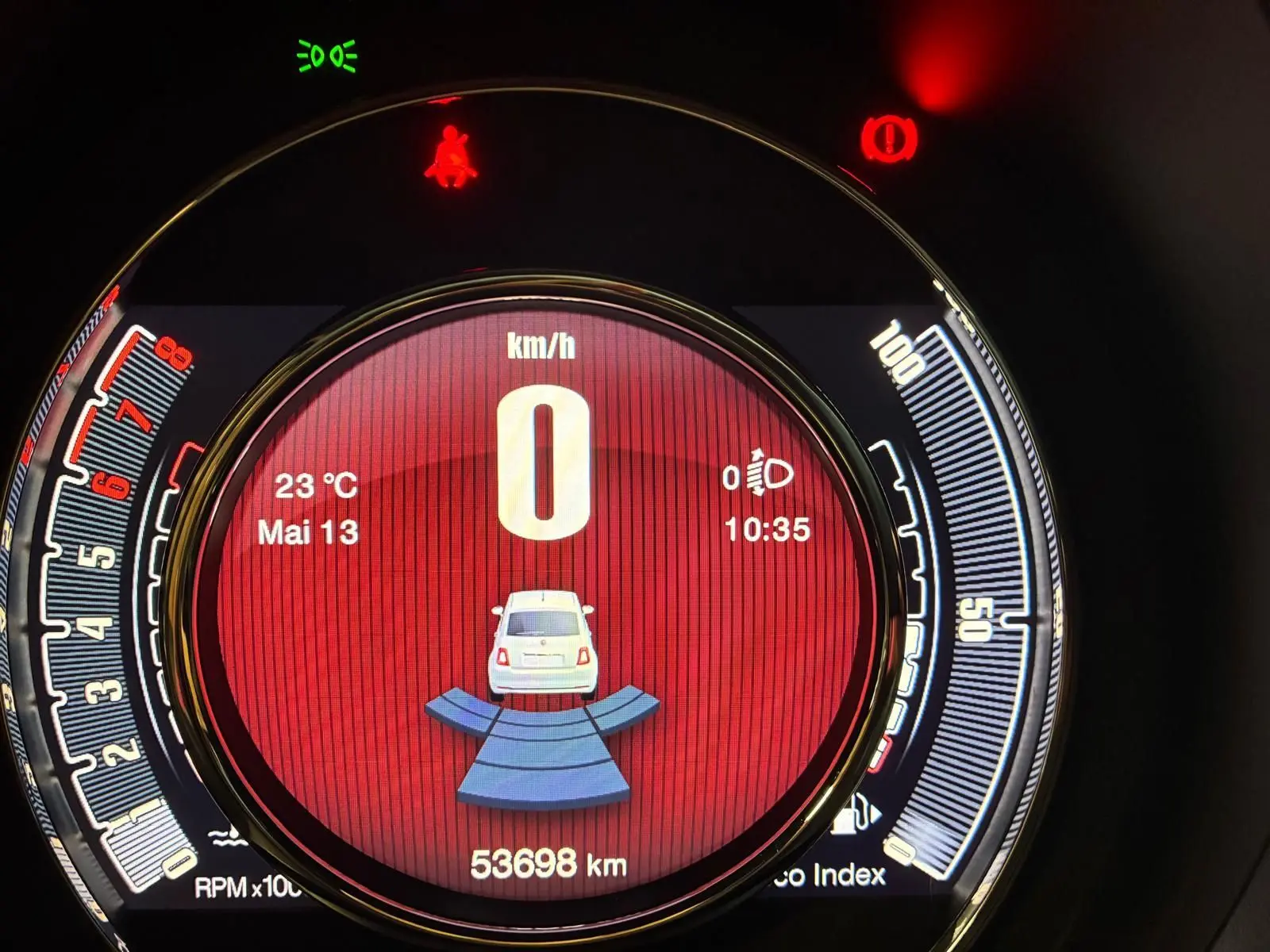Vue rapprochée du tableau de bord numérique de la Fiat 500, affichant la vitesse à 0 km/h et l'indicateur de stationnement actif.