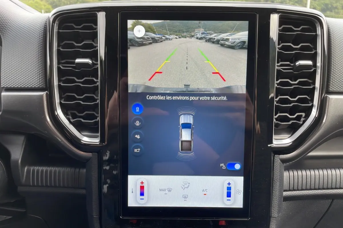 Écran central du Ford Ranger 2025 montrant la caméra de recul avec guidage coloré dans un intérieur noir.