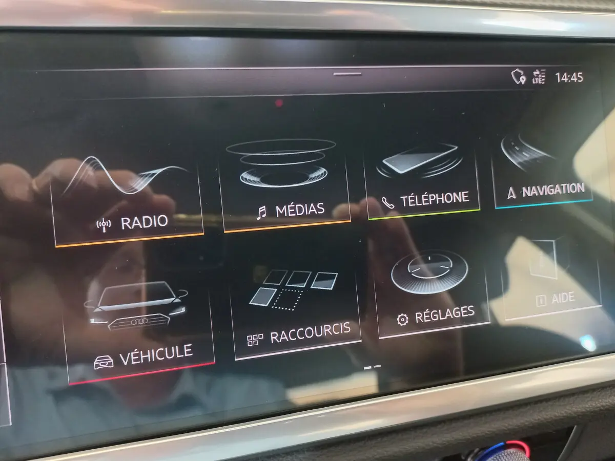 Écran tactile central de l'Audi Q3 Sportback 35 TDI noir, affichant les menus radio, médias, téléphone et navigation.