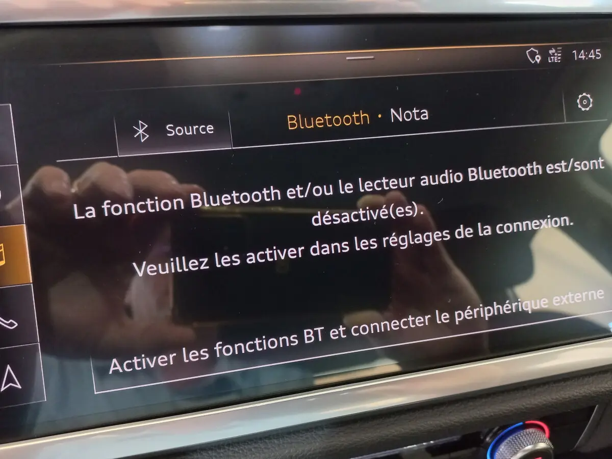Écran tactile central affichant un message Bluetooth dans l'habitacle noir d'un Audi Q3 Sportback 2020.