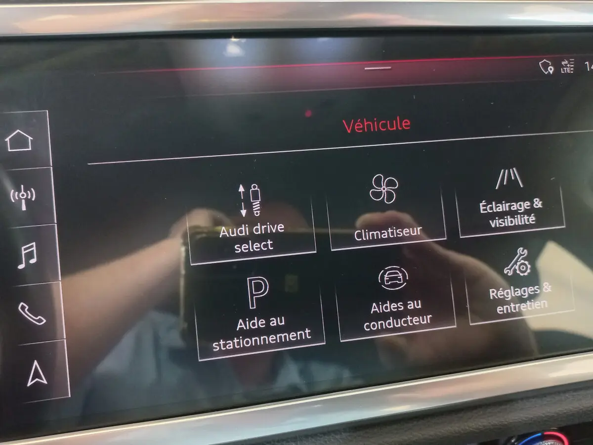 Écran tactile central de l'Audi Q3 Sportback 35 TDI noir, affichant les options de véhicule et aides à la conduite.