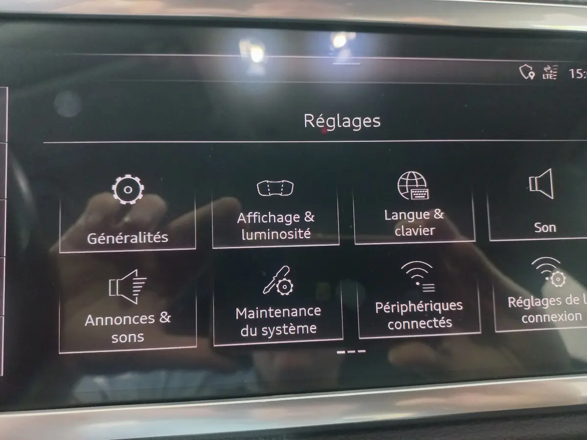 Écran tactile du système multimédia affichant le menu Réglages dans l'Audi Q3 Sportback noir de 2020.