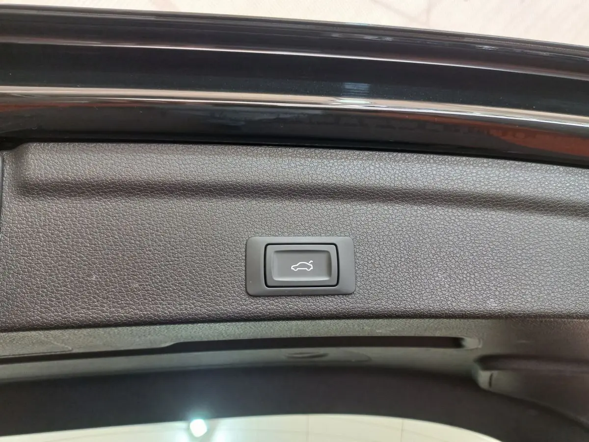 Bouton d'ouverture électrique du coffre sur la partie intérieure du hayon noir de l'Audi Q3 Sportback 2020.