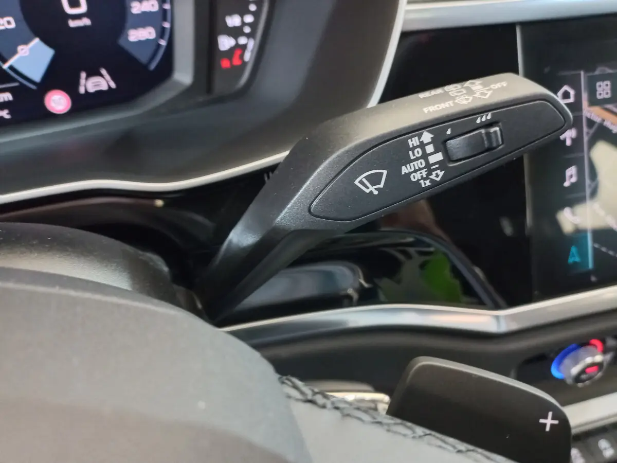 Gros plan sur la manette de commande des essuie-glaces dans l'habitacle noir de l'Audi Q3 Sportback 2020.