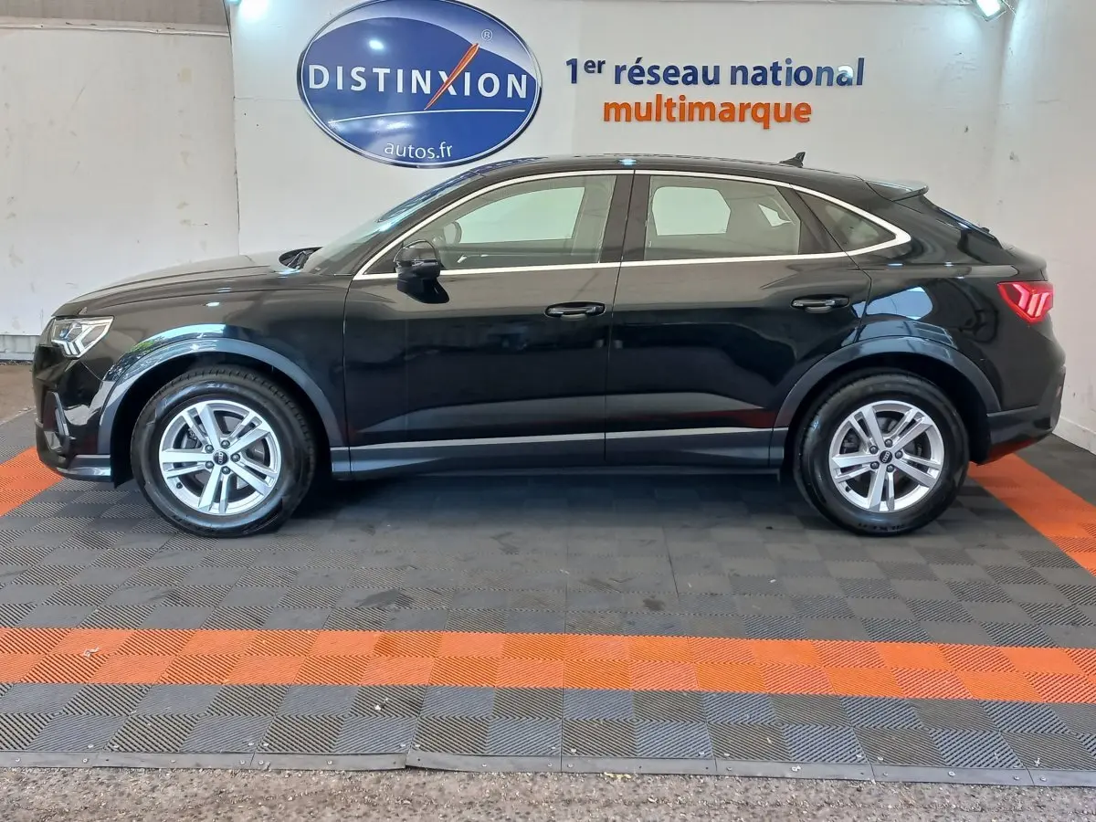 Profil côté gauche d'un Audi Q3 Sportback noir 2020, soulignant ses lignes fluides et ses feux arrière LED distinctifs.