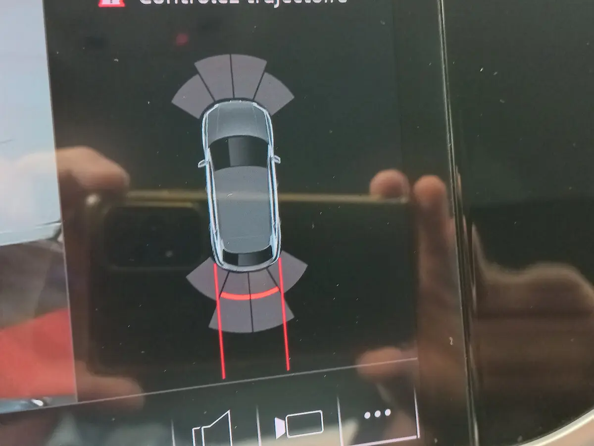 Affichage tactile montrant la vue de dessus du Audi Q3 Sportback noir avec guidage de trajectoire au stationnement arrière.