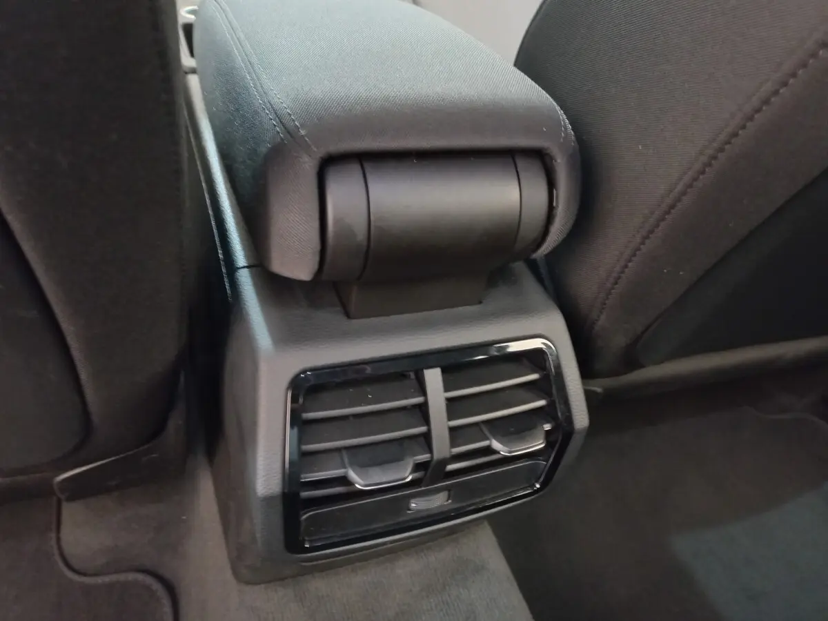 Détail des aérateurs arrière noirs et accoudoir central entre les sièges arrière d'un Audi Q3 Sportback noir.