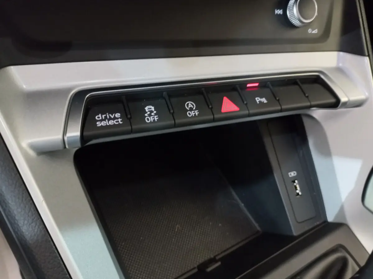 Gros plan sur la console centrale de l'Audi Q3 Sportback 35 TDI, boutons de contrôle et port USB visibles.