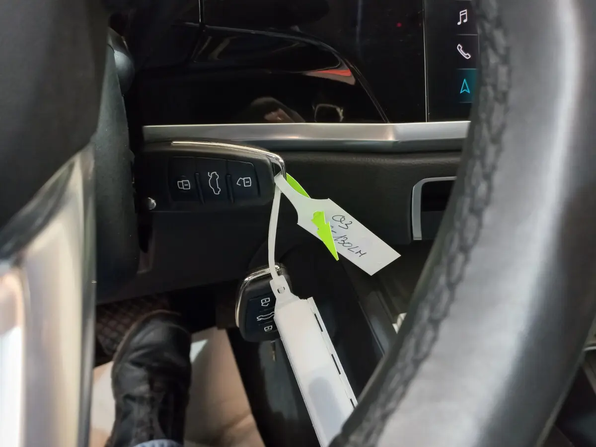 Gros plan sur la clé noire de l'Audi Q3 Sportback 35 TDI avec étiquette, près du tableau de bord et volant cuir.