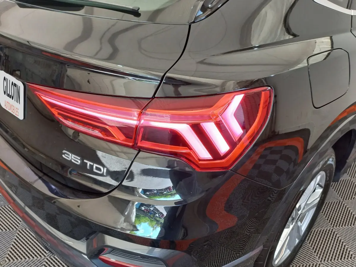 Gros plan sur l'arrière droit noir brillant de l'Audi Q3 Sportback 35 TDI avec feu LED distinctif allumé.