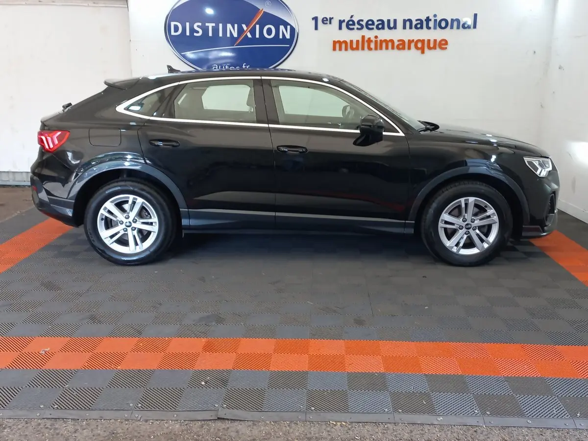 Audi Q3 Sportback noir vue de profil côté gauche, avec lignes fluides et jantes alliage argentées.