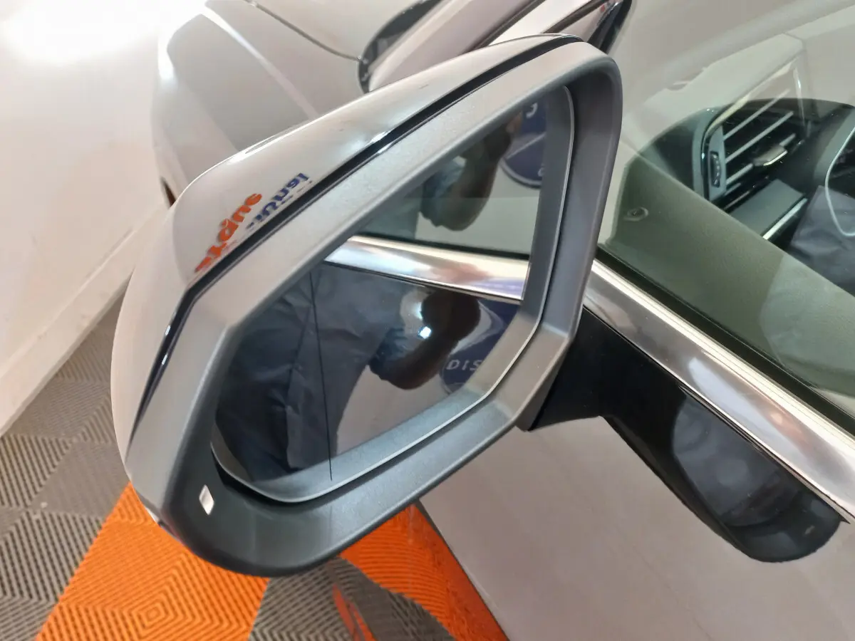 Rétroviseur droit gris métallisé de l'Audi Q3 Sportback noir, avec reflet intérieur et cadre chromé visible.