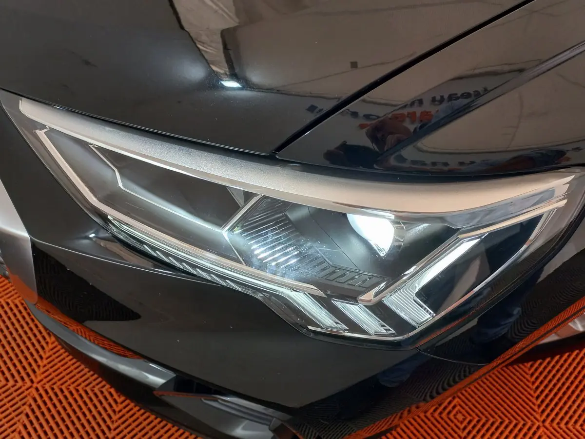 Gros plan sur le phare avant droit du SUV Audi Q3 Sportback noir, mettant en valeur son design LED distinctif.