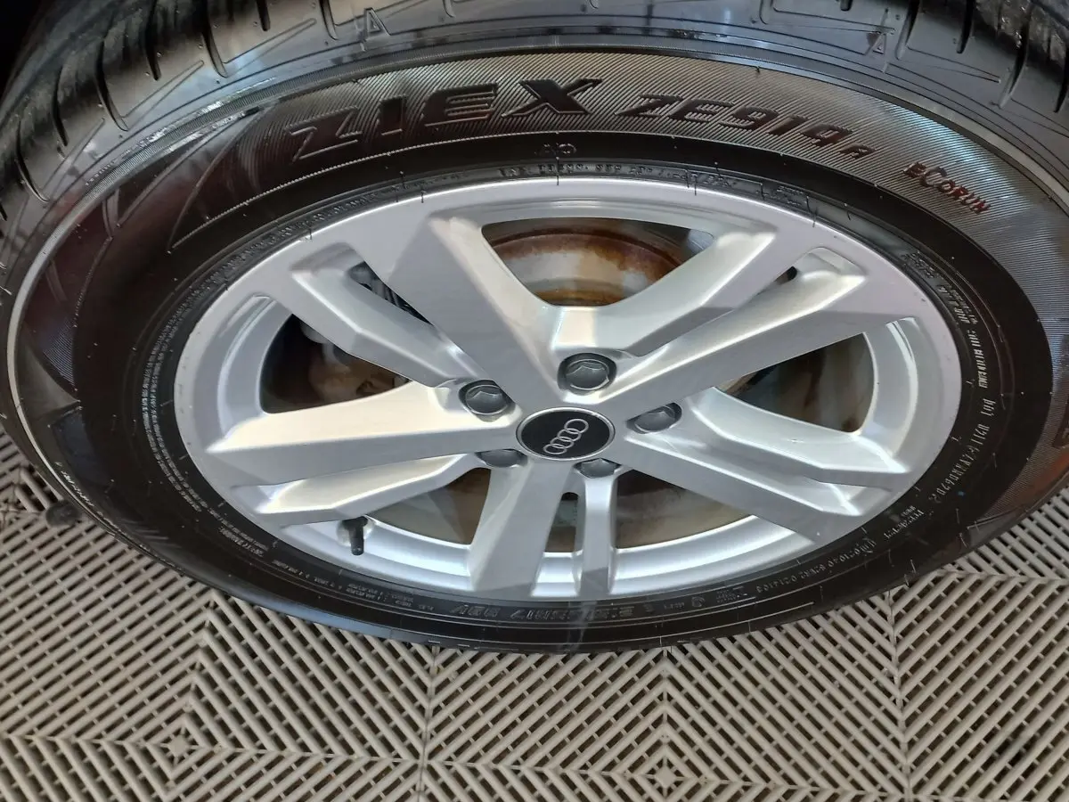 Gros plan sur la jante argentée avec logo Audi d’un Audi Q3 Sportback noir, mettant en valeur le pneu Nexen.