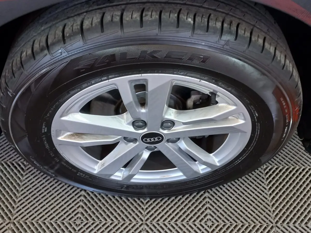 Gros plan sur la jante argentée et le pneu Falken d’un Audi Q3 Sportback noir, vue latérale rapprochée.