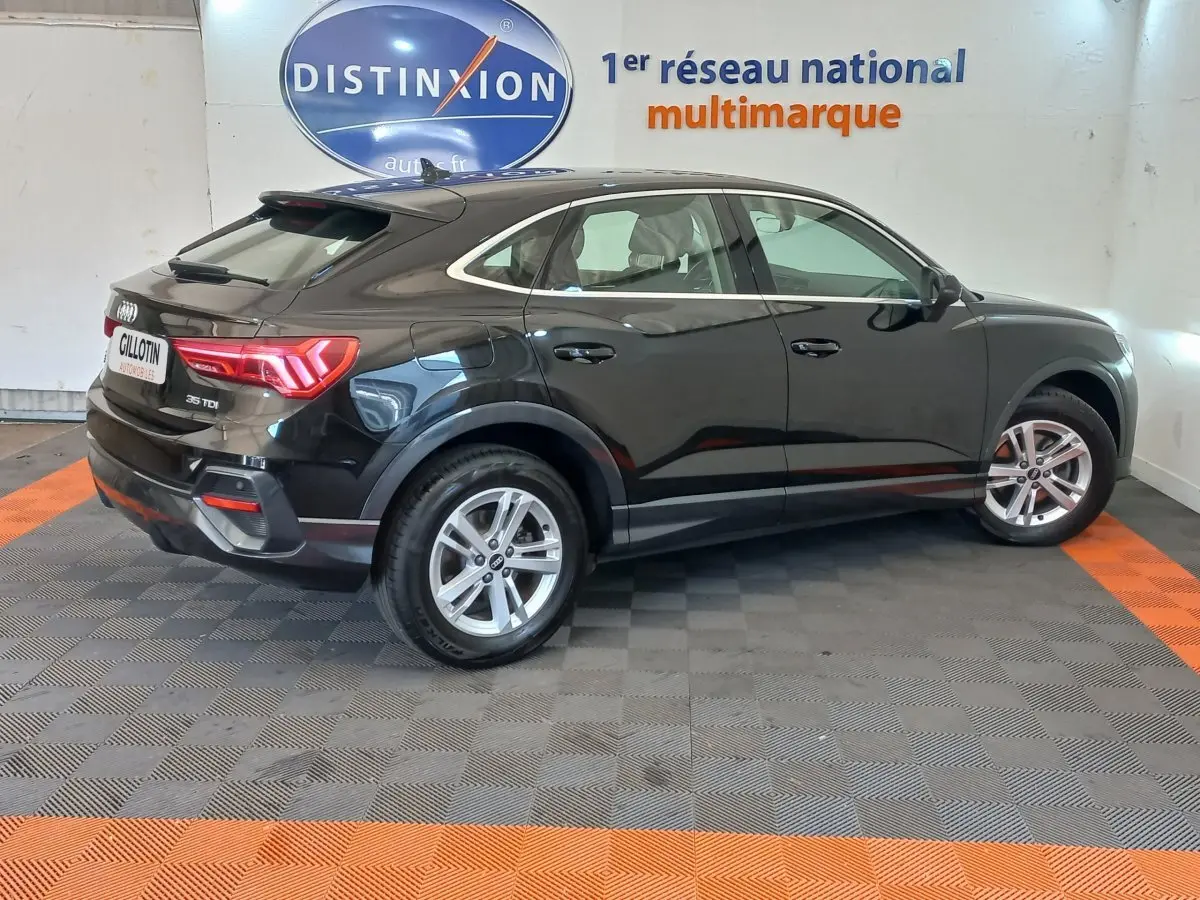 Audi Q3 Sportback noir vue de profil côté droit, soulignant ses lignes fluides et ses feux arrière LED distinctifs.