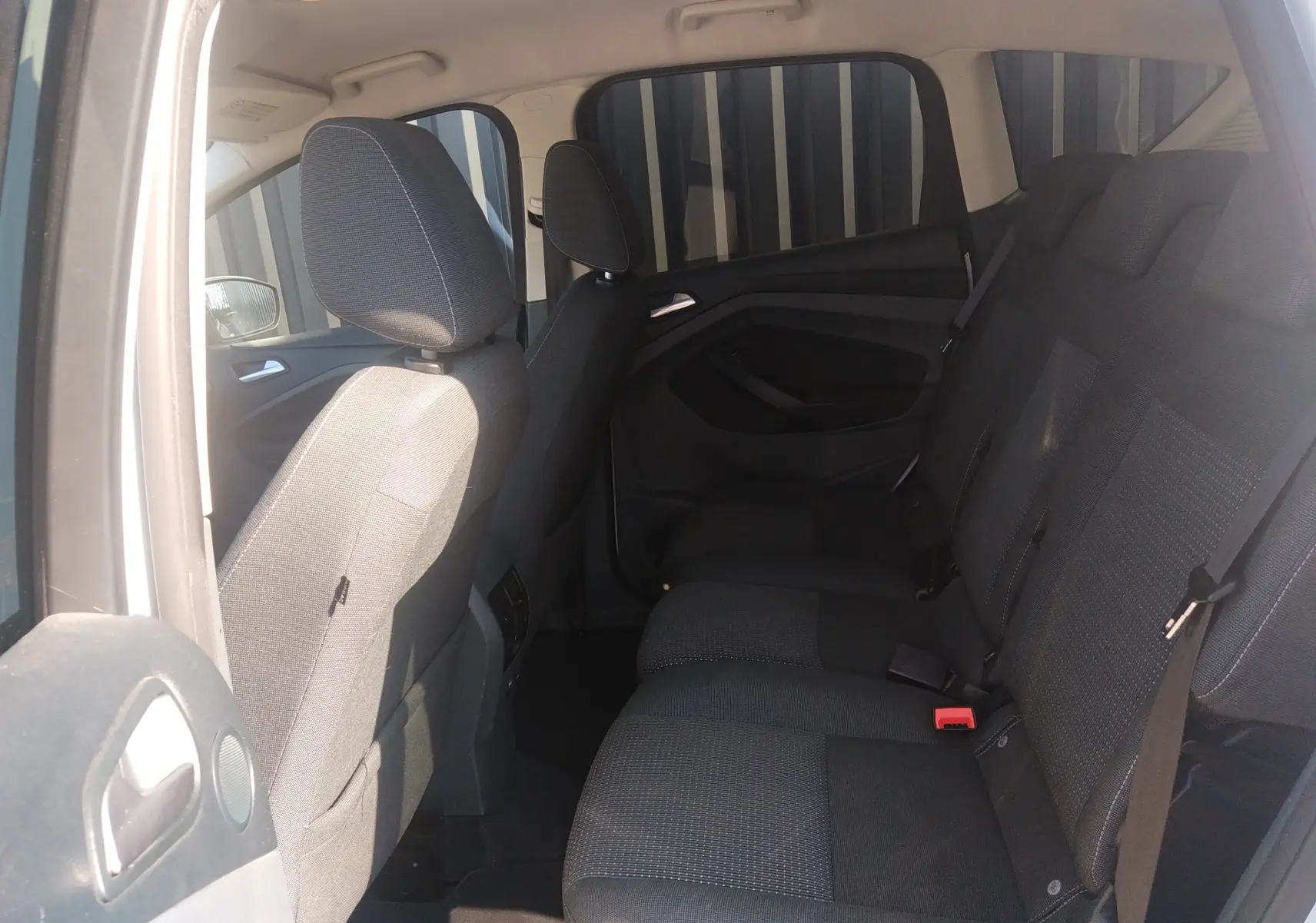 Vue intérieure côté gauche montrant les sièges arrière en tissu noir du Ford C-MAX blanc 2013.
