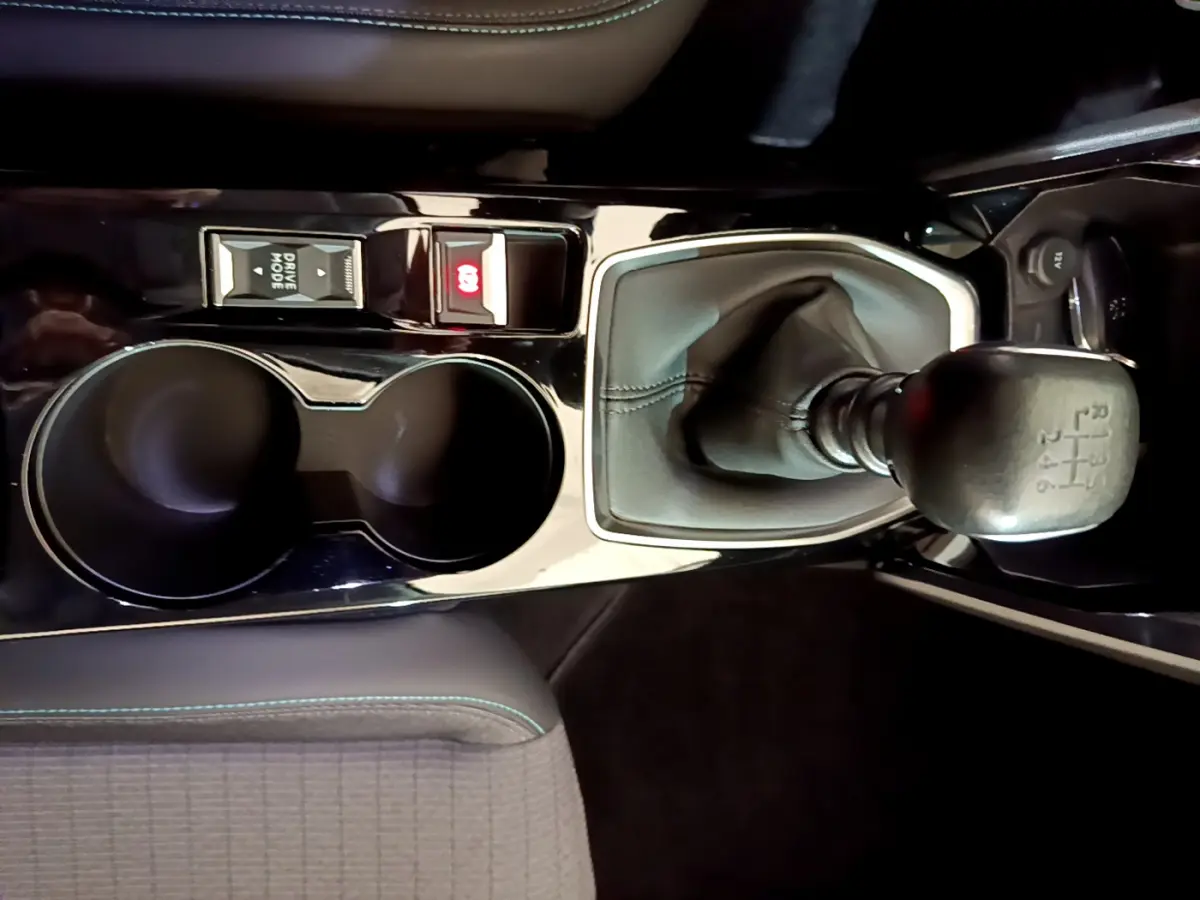 Gros plan sur la console centrale noire du Peugeot 2008 avec levier de vitesse manuel et boutons de commande.
