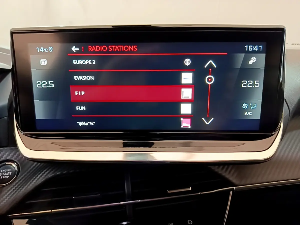 Écran tactile central du tableau de bord du Peugeot 2008 PureTech noir, affichant les stations radio et la climatisation à 22,5°C.