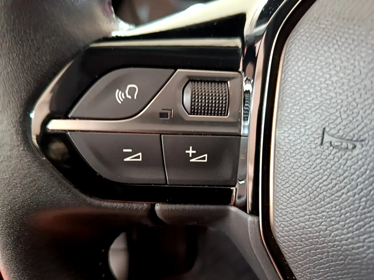 Gros plan sur les commandes gauche du volant cuir noir du Peugeot 2008 PureTech 130 S&S Allure Business 2021