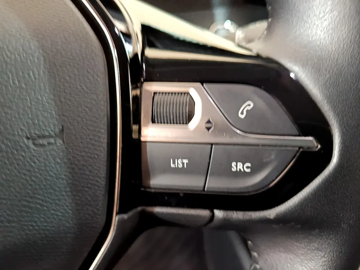 Gros plan sur les commandes du volant noir du Peugeot 2008 PureTech 130 S&S Allure Business 2021, boutons appel et liste.