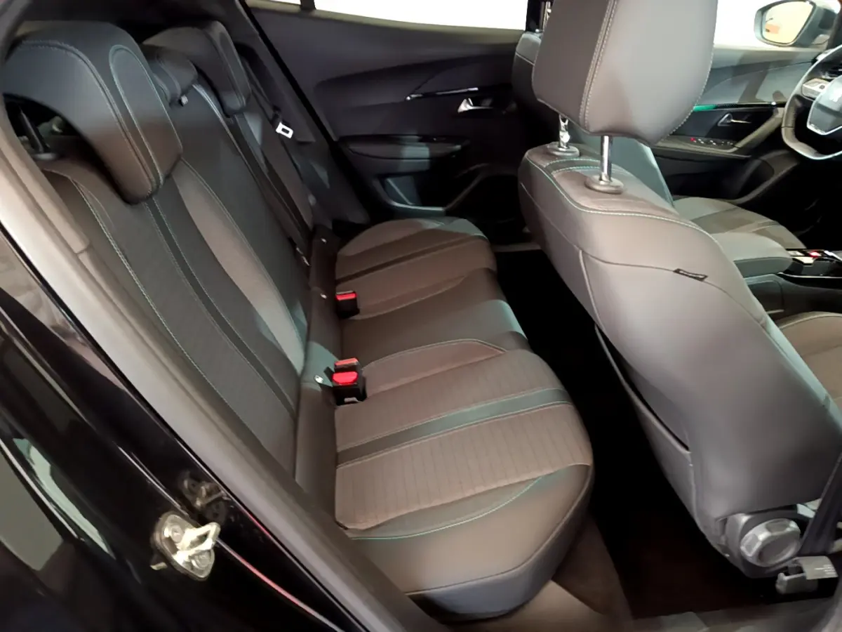 Vue intérieure côté gauche sur la banquette arrière et sièges avant en tissu gris du Peugeot 2008 noir 2021 PureTech 130 Allure Business