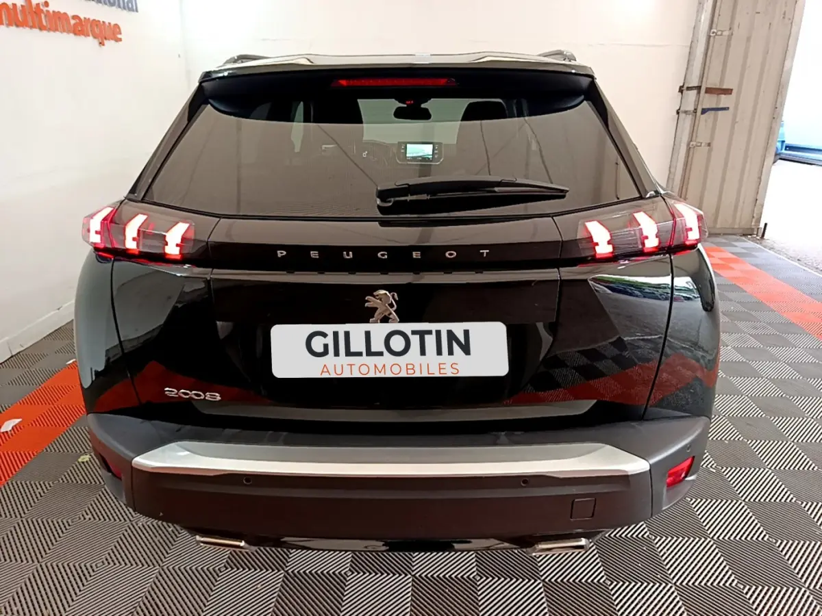 Vue arrière d'un Peugeot 2008 noir avec feux arrière LED caractéristiques et logo lion central visible.