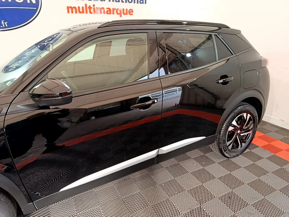 Profil côté gauche d'un Peugeot 2008 noir avec jantes alliage et rétroviseurs noirs brillants.