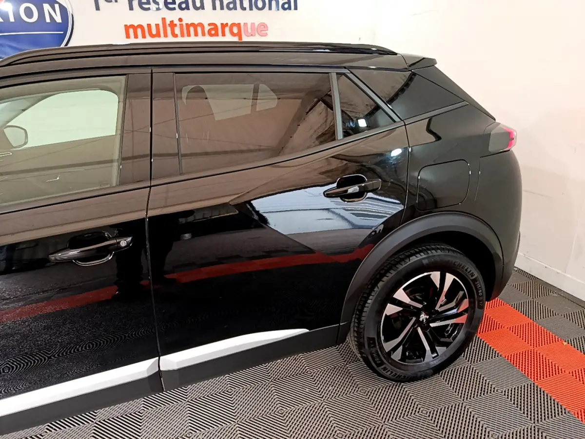 Profil côté droit du Peugeot 2008 noir 2021 avec jantes alliage et poignées de porte assorties.