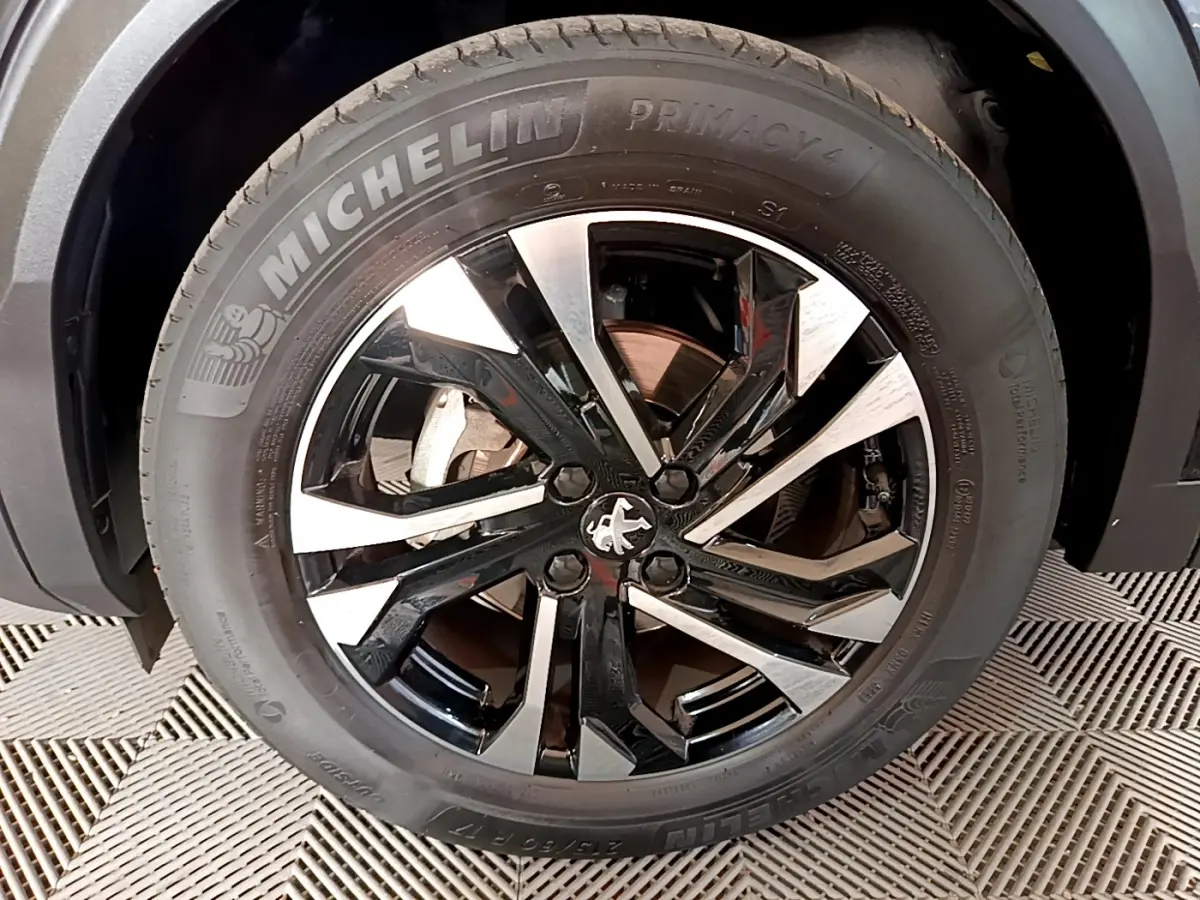 Gros plan sur la jante noire et argentée d’un Peugeot 2008 PureTech 130 S&S Allure Business noir avec pneu Michelin Primacy 4.