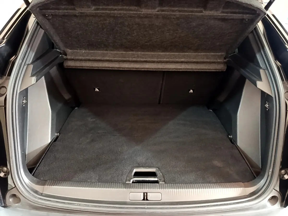 Coffre ouvert vu de l'arrière d'un Peugeot 2008 noir, montrant un espace de chargement propre et spacieux.