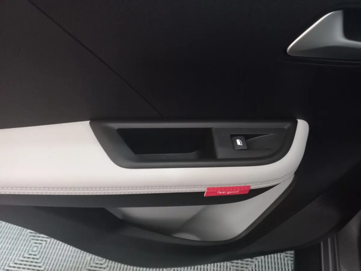 Détail de la porte intérieure côté droit de la Citroën C3 hybride 2025, avec insert gris clair et bouton de verrouillage.