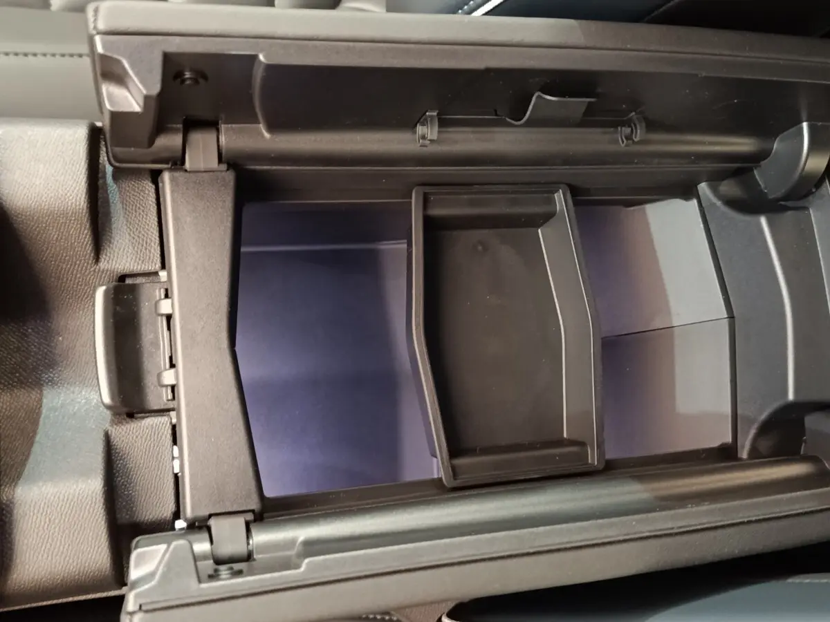 Vue rapprochée de la boîte à gants ouverte du Citroën C5 Hybride 2026 avec intérieur noir et compartiment modulable.