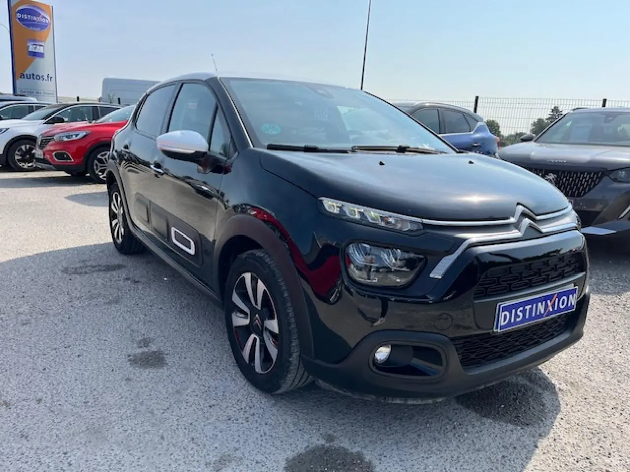 Citroën C3 noire vue en 3/4 avant droit, avec jantes alliage et rétroviseurs blancs contrastants.