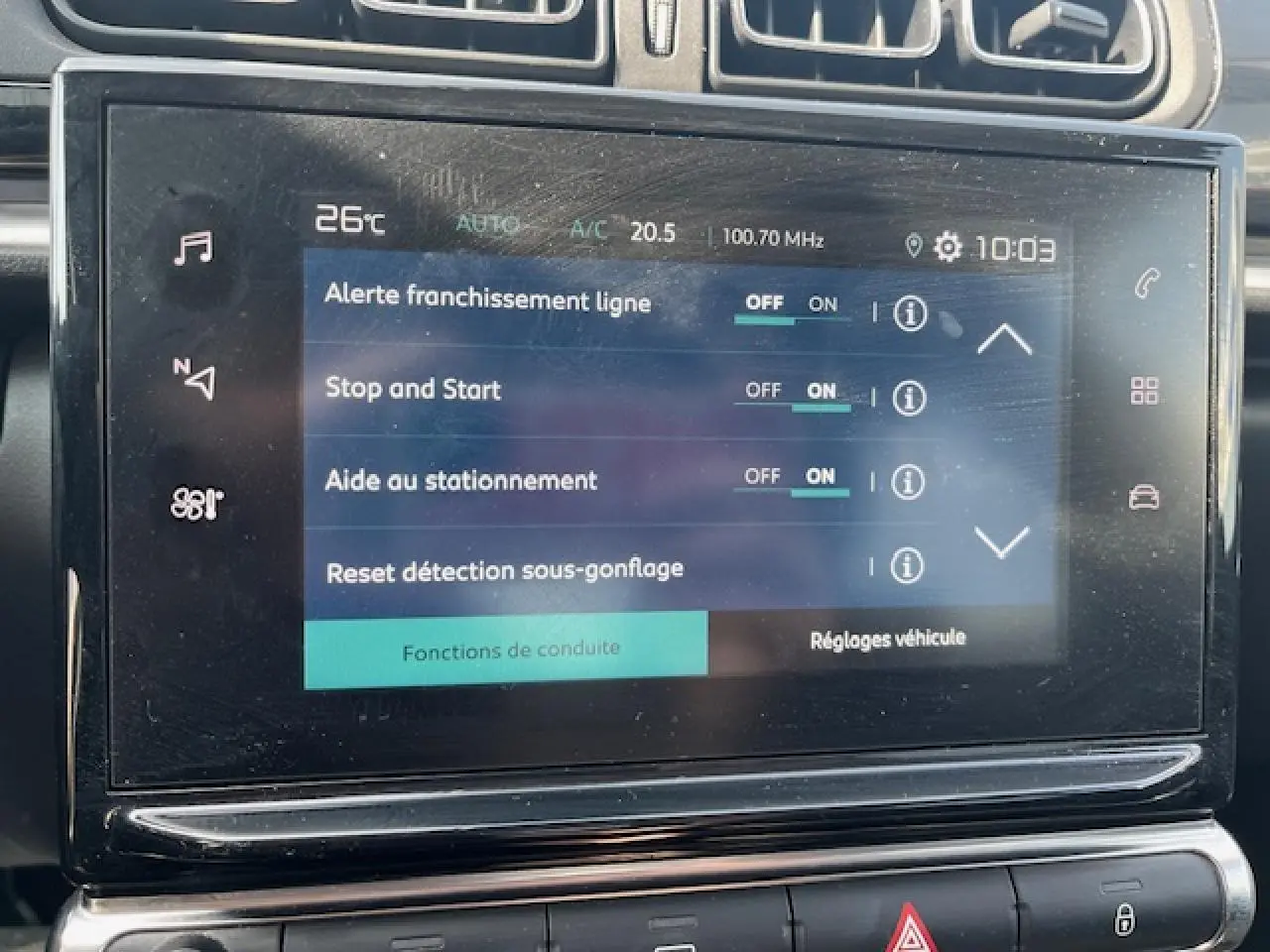 Gros plan sur l'écran tactile central de la Citroën C3 noire 2023 montrant les réglages d'aide à la conduite.