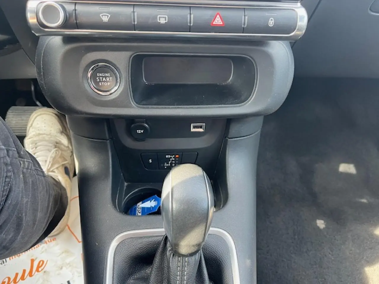 Gros plan sur la console centrale noire de la Citroën C3 2023, avec levier de boîte automatique et bouton start/stop.