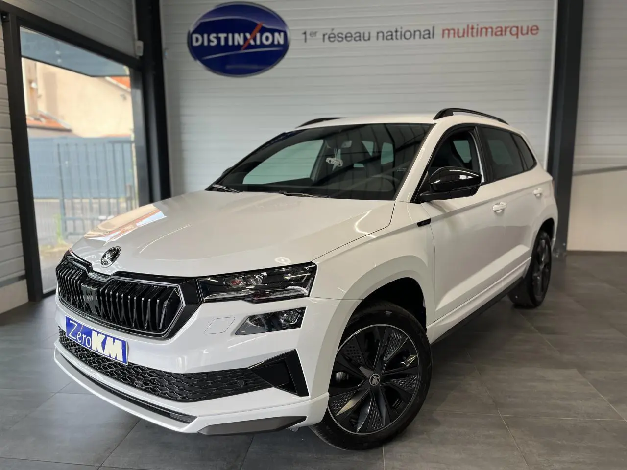 SUV SKODA KAROQ blanc en 3/4 avant droit avec jantes anthracite et calandre noire sportive