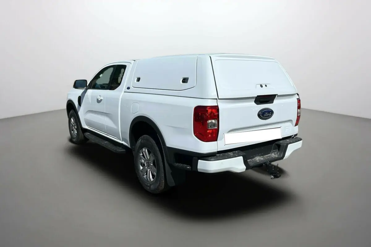 Ford Ranger blanc glacier en vue 3/4 arrière droit avec benne couverte et attelage visible